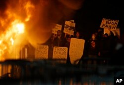 Protestors watch a fire on Sproul Plaza during a rally against the scheduled speaking appearance by Breitbart News editor Milo Yiannopoulos on the University of California at Berkeley campus on Wednesday, Feb. 1, 2017, in Berkeley, Calif.