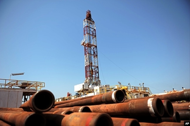 FILE - Drilling tubing is piled next to a drilling site in the Unity oil field, South Sudan, in 2010.