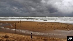 Một cậu bé Ấn Độ chơi trên bờ biển thuộc Vịnh Bengal trong khi bão chuẩn bị tràn vào. 