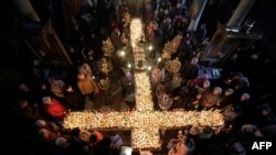 Worshippers gather around candles stuck to jars of honey, arranged as a cross, during mass for the 'sanctification of honey' at the Presentation of the Blessed Virgin church in the town of Blagoevgrad, some 100 km (62 miles) south of the Bulgarian capital