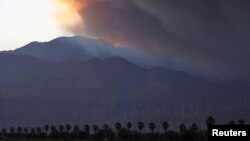 A smoke plume from the Lake Fire in the San Bernardino National Forest is seen at sunset, rising over the Coachella Valley from Palm Springs, California, June 18, 2015. 