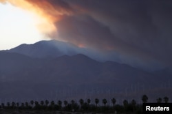 A smoke plume from the Lake Fire in the San Bernardino National Forest is seen at sunset, rising over the Coachella Valley from Palm Springs, California, June 18, 2015.