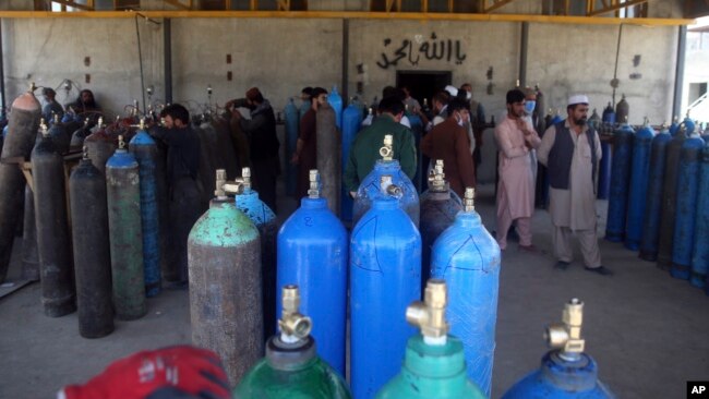 People line up for free oxygen at a privately owned oxygen factory, in Kabul, Afghanistan, Thursday June 18, 2020. For seven years, Najibullah Seddiqi's oxygen factory sat idle in the Afghan capital Kabul.