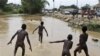 Crianças brincam na água, em Cabinda