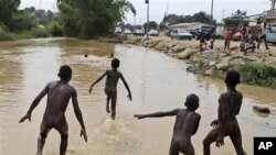 Crianças brincam na água, em Cabinda
