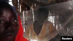 FILE - A Sudanese woman suffering from malaria sits inside her makeshift house in Golo, Fashoda county in Upper Nile State May 29, 2014.