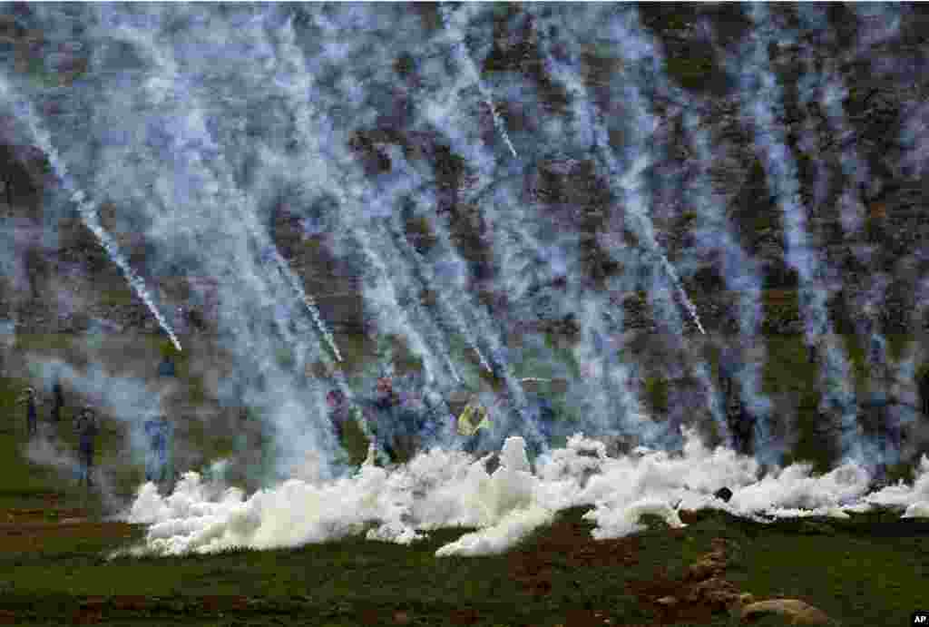 Tear gas canisters are fired by Israeli troops at Palestinians during clashes after the funeral of Hamdi Naasan in al-Mughair village near the West Bank city of Ramallah. Nassan was shot killed in clashes with Israeli settlers, Palestinians said.