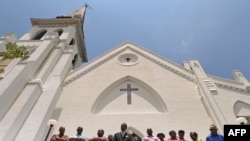 Members of the Emanuel African Methodist Church stand in front of the church and announce that services and Sunday school will go on as scheduled Sunday, four days after the pastor and eight others were slain in the church in Charleston, S.C., June 20, 20