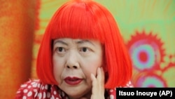 In this photo taken Wednesday, Aug. 1, 2012, Japanese avant-garde artist Yayoi Kusama, wearing a bright red wig and a Louis Vuitton polka dot scarf, speaks during an interview at her studio in Tokyo.