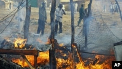 Men look at a market destroyed by a Sudanese air force air strike in Rubkona, near Bentiu, South Sudan, April 23, 2012.