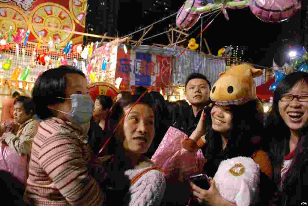 有香港市民戴著象徵馬年的帽逛花市