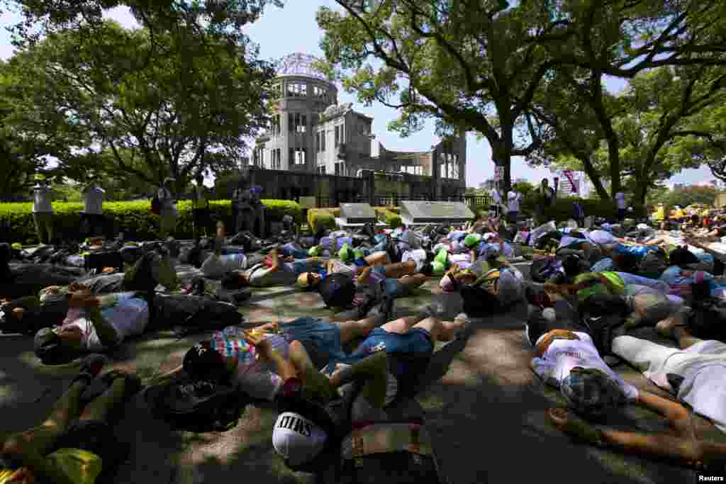 Anak-anak sekolah Jepang melakukan aksi teatrikal berpura-pura sebagai korban bom atom di depan Kubah Bom Atom di Hiroshima, Jepang bagian barat (5/8).&nbsp;