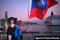 资料照：一名男子在香港维多利亚湾手持台湾旗帜庆祝双十节。（2019年10月10日）