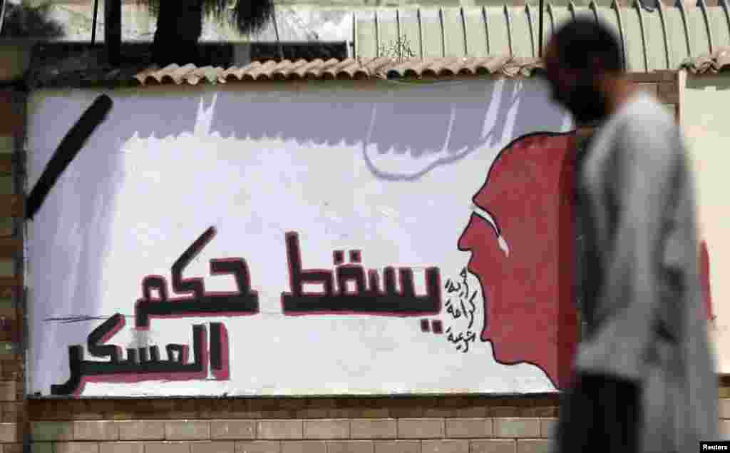 A member of the Muslim Brotherhood walks in front of graffiti that reads "Down with the military rules" in Cairo's Rabaa el-Adawiya Square, July 28, 2013.