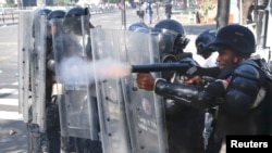 Policías antimotines disparan gas lacrimógeno a los manifestantes, el sábado, en Caracas.
