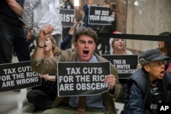 FILE - Protesters shout their disapproval of the Republican tax bill outside the Senate Budget Committee hearing room on Capitol Hill in Washington, Nov. 28, 2017.