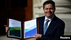 Ireland's Minister for Finance Paschal Donohoe displays a copy of the 2019 budget on the steps of Government Buildings in Dublin, Ireland Oct. 9, 2018.