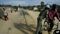 FILE: A U.N. soldier searches a man on a bicycle in the streets of Bunia, Democratic Republic of Congo, March 6, 2005. Congo's government says bodies have been found in the Central Kasai region where two U.N. experts and their colleagues recently disappeared.