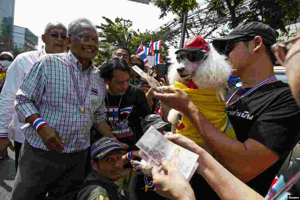 Anti-government protest leader Suthep Thaugsuban receives donations from supporters as he leads protesters in a march in Bangkok, Jan. 19, 2014. 