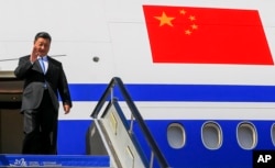 Chinese President Xi Jinping gestures as he arrived at Vladivostok, Russia, to attend the Eastern Economic Forum, Tuesday, Sept. 11, 2018.