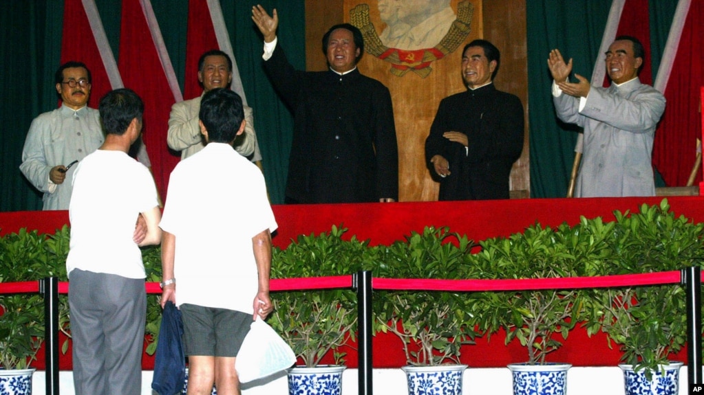 在北京举办的中共建党纪念日的展览中，有人观看中共领袖塑像。左起：任弼时，刘少奇，毛泽东，周恩来和朱德（2004年6月29日）(photo:VOA)