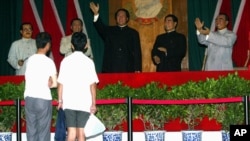 在北京举办的中共建党纪念日的展览中，有人观看中共领袖塑像。左起：任弼时，刘少奇，毛泽东，周恩来和朱德（2004年6月29日）