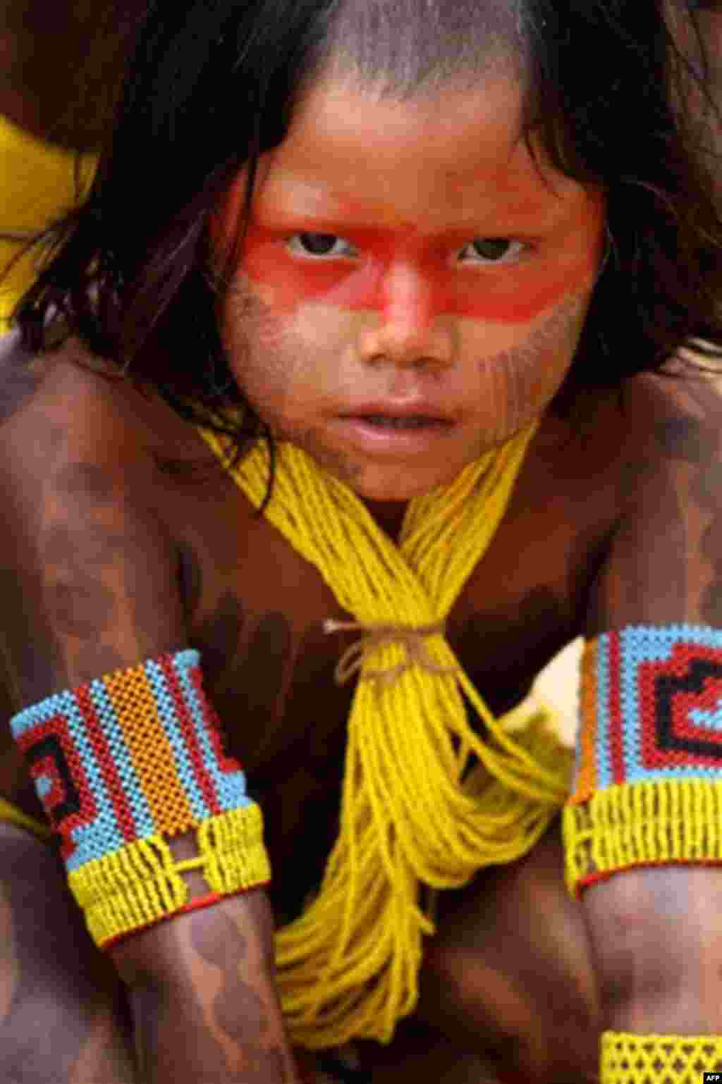 An Xicrin child wears traditional paint and beads while attending a canoe race competition on the Tocantins River, during the Indigenous Games on the island of Porto Real in the city of Porto Nacional, Brazil, Friday Nov. 11, 2011. Indigenous people from 