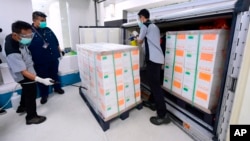 Para petugas menyemprotkan disinfektan pada kotak berisi vaksin eksperimental untuk Covid-19 produksi perusahaan China Sinovac, setibanya di fasilitas perusahaan farmasi milik negara Bio Farma, di Bandung, Jawa Barat, 7 Desember 2020.
