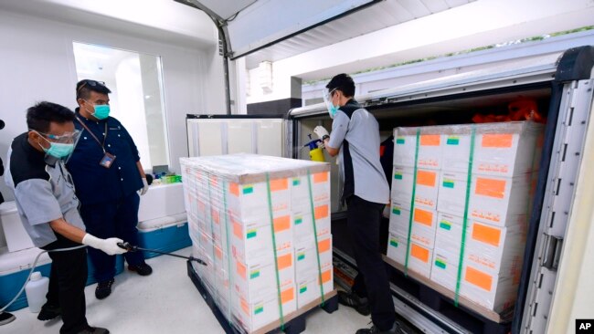 印度尼西亚总统宫发布照片，显示12月7日印尼工人正在给从中国运抵的新型冠状病毒试验疫苗盒子喷洒消毒剂。
