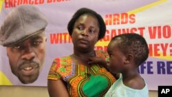 FILE - Sheffra Dzamara, wife of activist Itai Dzamara, holds her 2-year-old daughter and speaks to The Associated Press in Harare, March 8, 2016. Dzamara was pleading for the return of her activist husband, abducted by suspected state security agents a ye