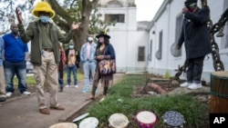 Darryl Montana, left, the son of the late Big Chief Allison "Tootie" Montana, joins others at the blessing of the tambourines outside St. Augustine Catholic Church for the start of Twelfth Night in New Orleans on Wednesday, Jan. 6, 2021. (Chris Granger)