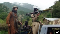 FILE - Pakistani Taliban patrol in their stronghold of Shawal in Pakistani tribal region of South Waziristan..
