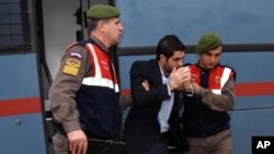 Prison guards escort Asem Alfrhad before his trial in Aegean resort of Bodrum, Turkey, Feb. 11, 2016. Two alleged smugglers of migrants are on trial accused of causing the death of 3-year-old Syrian migrant boy Aylan Kurdi and four other people. 