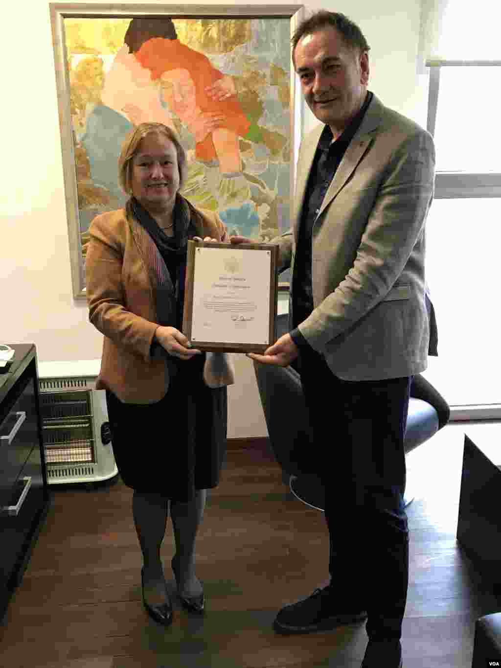 VOA Director Amanda Bennett presents Senad Hadzifejzovic, owner of VOA's Bosnian affiliate FACE TV, with a certificate of appreciation, Sept 22, 2017. 