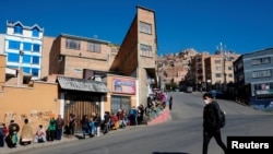 A man walks past a line of people waiting to collect their pension as the spread of the coronavirus disease (COVID-19) continues in La Paz, Bolivia, April 8, 2020.