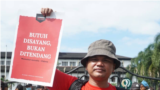 Seorang jurnalis mengangkat poster dalam aksi Hari Buruh, menuntut penghapusan kekerasan terhadap awak media (courtesy: Aliansi Jurnalis Independen (AJI) Bandung)