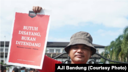 Seorang jurnalis mengangkat poster dalam aksi Hari Buruh, menuntut penghapusan kekerasan terhadap awak media (courtesy: Aliansi Jurnalis Independen (AJI) Bandung)