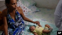 Janine Santos dan bayinya Shayde Henrique yang berusia 3 bulan dan lahir dengan microcephaly di rumah mereka di Joao Pessoa, Brazil (23/2). (AP/Andre Penner)