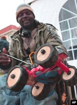 Irrepressible Zimbabwean ‘recycler artist’ Admire Munyuki selling toy tractors from his wheelchair at a festival in Cape Town, South Africa