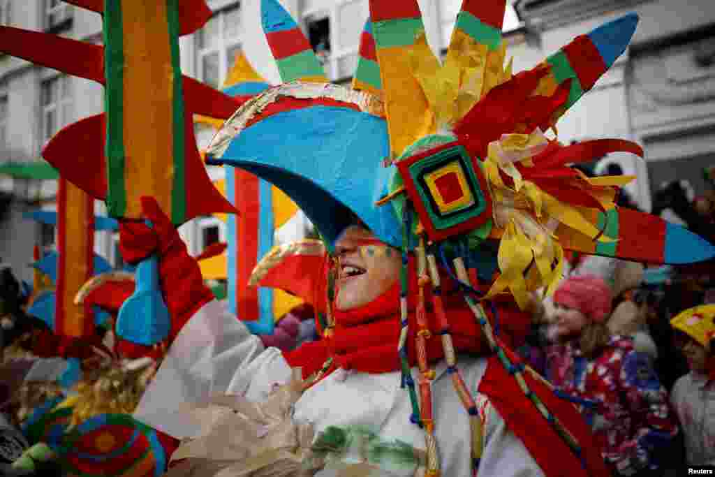 People dressed in fancy clothes take part in a performance as students and teachers of a local school celebrate Maslenitsa, also known as Pancake Week, a holiday marking the end of winter, in central Moscow, Russia.