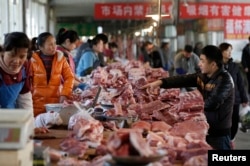 FILE - Meat stalls are seen at a market in Beijing, China, March 25, 2016.