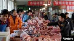 Standurile de carne sunt văzute pe o piață din Beijing, China. China plasează tarife de până la 25% la importurile de porc din SUA ca reacție la impozitele importurilor pe oțel și aluminiu anunțate de SUA în martie.