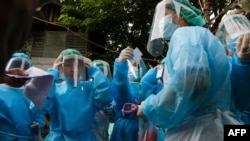 ရန်ကုန်မြို့မှာ အိမ်တိုင်ရာရောက် COVID-19 စစ်ဆေးပေးဖို့ ပြင်ဆင်နေတဲ့ ကျန်းမာရေးဝန်ထမ်းများ။ (မေ ၁၇၊ ၂၀၂၀)