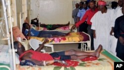 Government officials visit injured people from Tuesday's suicide bomb explosion, in a hospital in Kano, Nigeria, Feb. 25, 2015.