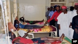 Government officials visit injured people from Tuesday's suicide bomb explosion, in a local hospital in Kano, Nigeria, Feb. 25, 2015.