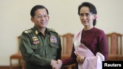 FILE - Myanmar's Commander-in-Chief Min Aung Hlaing (L) and National League for Democracy party leader Aung San Suu Kyi shake hands after their meeting in Naypyitaw, Dec. 2, 2015. 