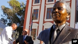 South African President Jacob Zuma (second l) talks with Mandla Mandela (l) after they and other dignitaries unveiled a bust of former South African President Nelson Mandela (r) at the South African Parliament in Cape Town, South Africa, April 28, 2014.