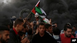 Warga Palestina melakukan aksi unjuk rasa memrotes blokade Israel di Gaza City, dekat perbatasan Israel, hari Jumat (26/10).