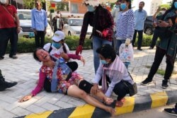 A woman lies on the sidewalk after security guards broke up a small protest near the Chinese embassy opposing alleged plans to boost Beijing's military presence in the country, in Phnom Penh, Cambodia October 23, 2020. REUTERS/Heng Mengheang