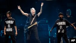 Roger Waters is joined onstage by children as he performs his song "Another Brick in the Wall" during his closing performance on day 3 of the 2016 Desert Trip music festival at Empire Polo Field, Oct. 9, 2016, in Indio, Calif. 